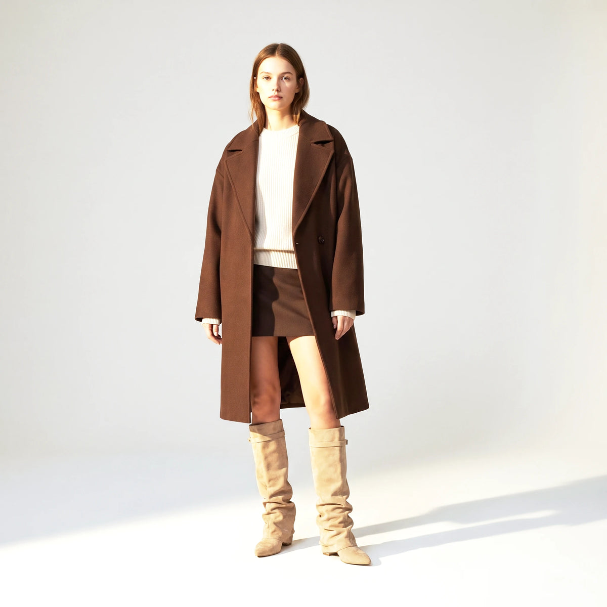 Woman wearing the beige Ravello knee boots with a brown wool coat