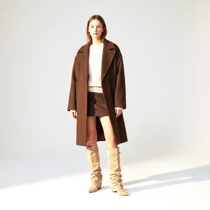Woman wearing the beige Ravello knee boots with a brown wool coat