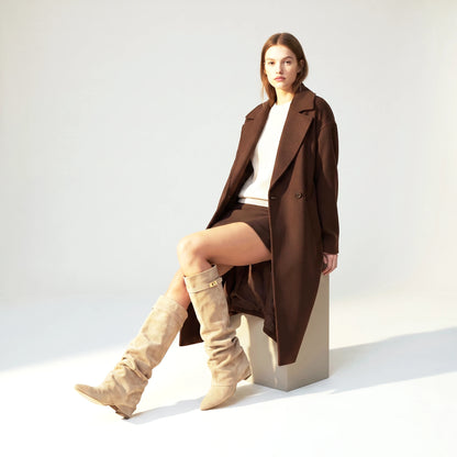 Seated view of the beige Ravello knee boots worn with bare legs