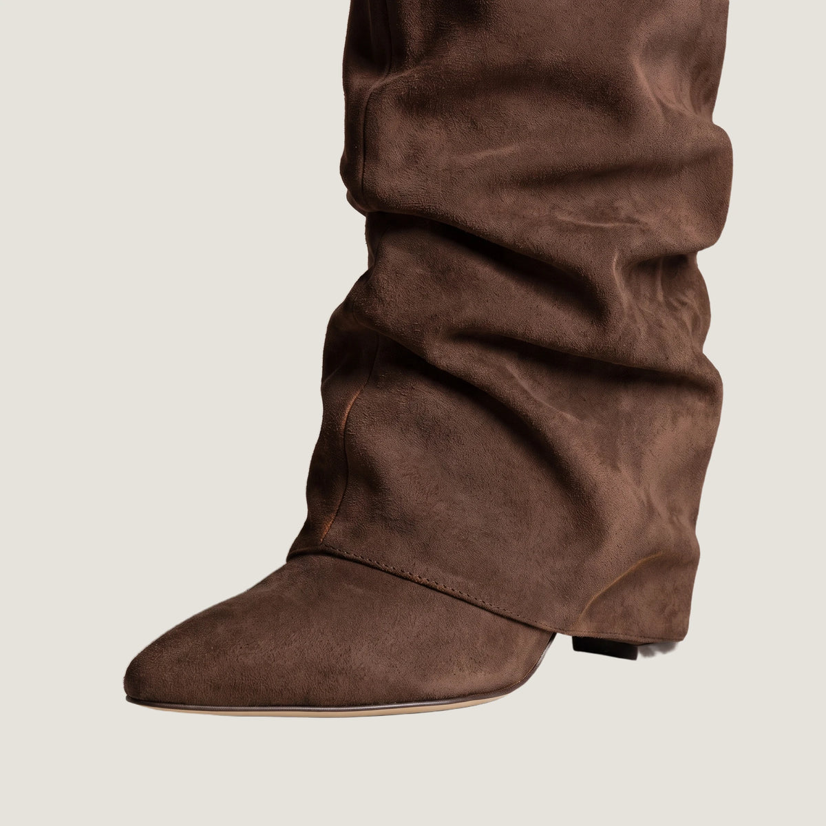 Close-up of the fold-over front panel and concealed wedge heel in dark brown