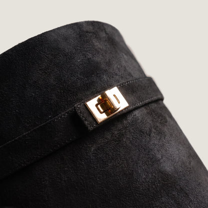 Close-up of the gold turnlock clasp on the black suede shaft strap