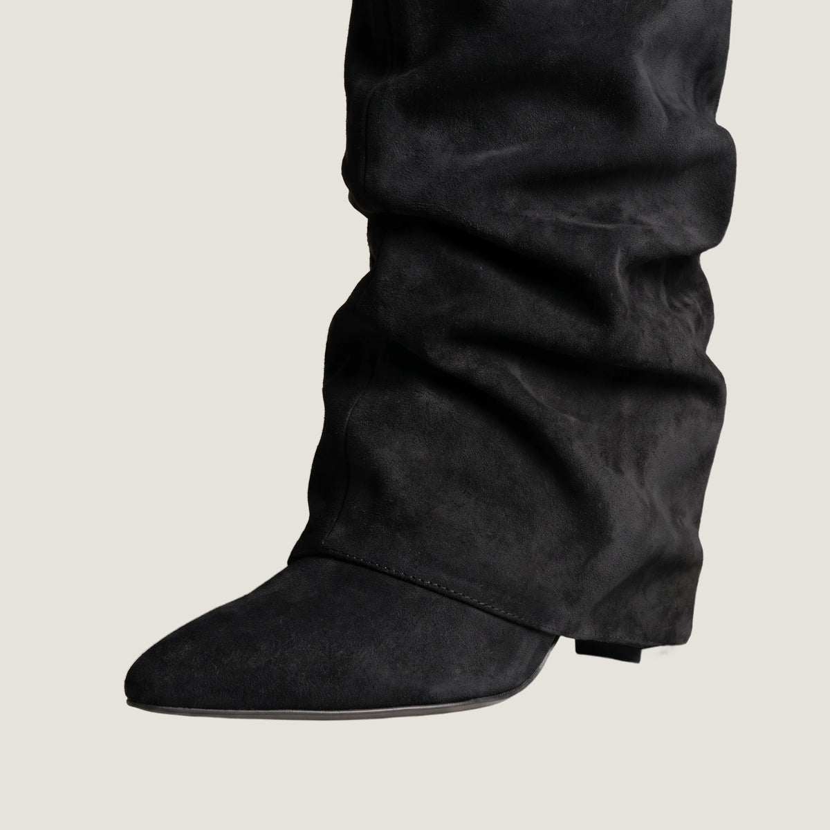 Close-up of the fold-over front panel and concealed wedge heel in black